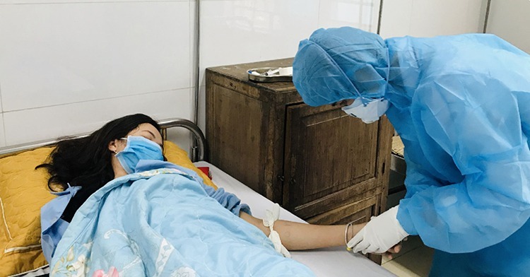 Nhân viên y tế ở Thanh Hóa chăm sóc nữ bệnh nhân nhiễm nCoV, hiện đã được xác định âm tính và xuất viện. Ảnh: Tô Hà