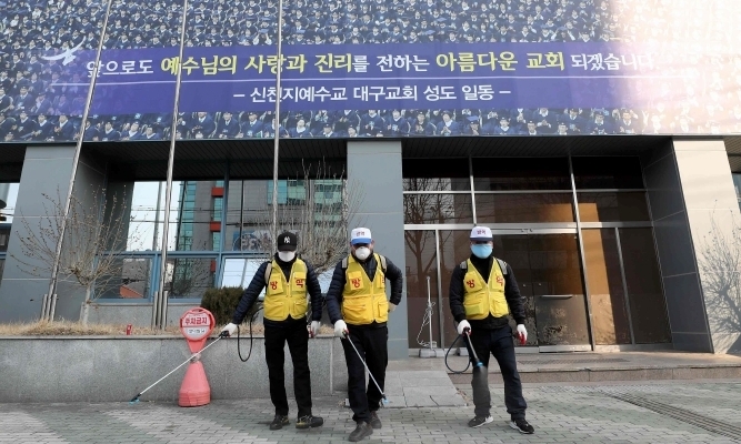 Nhân viên vệ sinh khử trùng khu vực trước chi nhánh của giáo phái Shincheonji tại Daegu ngày 20/2. Ảnh: AFP.