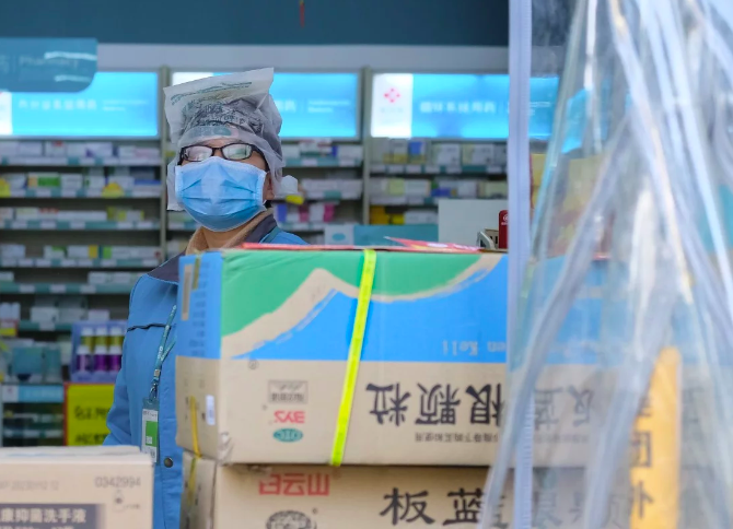 Một nhân viên cửa hàng thuốc tại Vũ Hán. Người dân mua thuốc tại đây và những cửa hàng khác đều phải khai báo danh tính thật. Ảnh: SCMP.