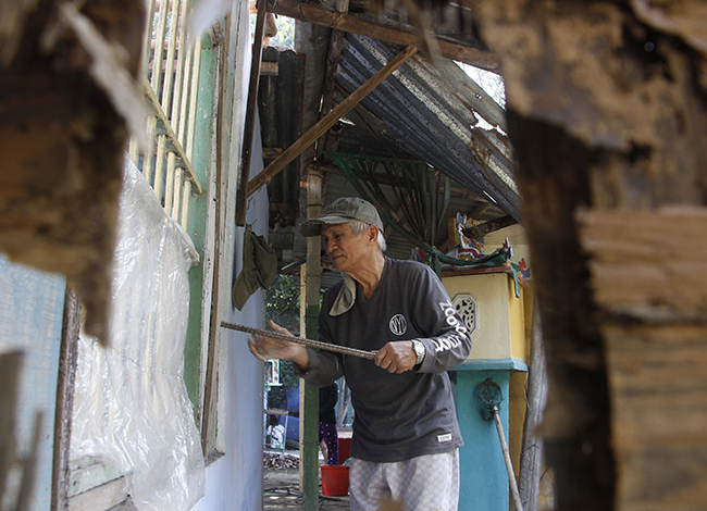 Ông Kiên tự tay tháo dỡ căn nhà mình sinh sống 30 năm qua. Ảnh: Võ Thạnh