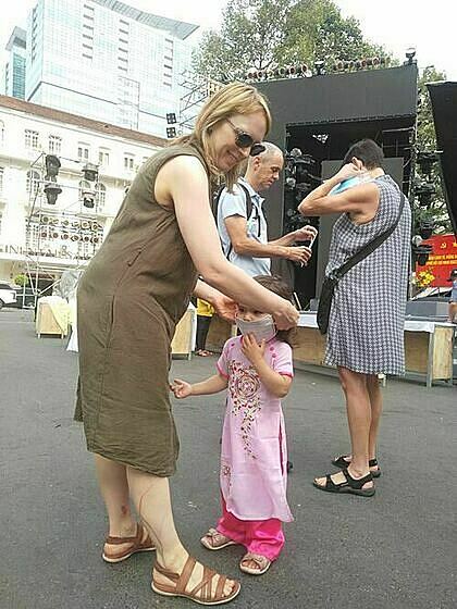 Một bé gái người nước ngoài được mẹ đeo khẩu trang y tế để bảo vệ sức khỏe. Ảnh: Nguyễn Nam. 