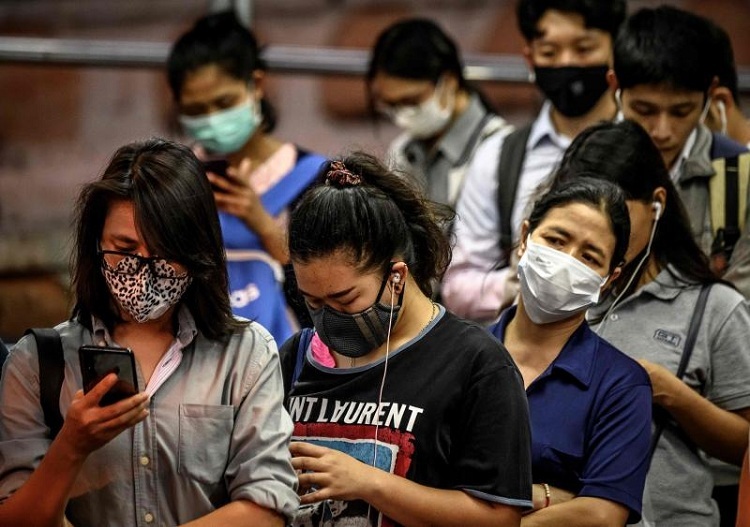 Người dân Thái Lan đeo khẩu trang, xếp hàng để lên thuyền qua sông Chao Phraya vào ngày 25/2. Ảnh: AFP