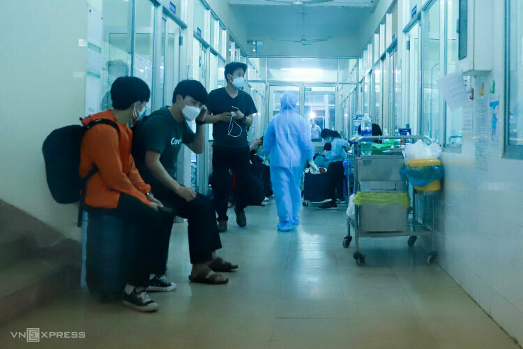 Nhóm khách Daegu để valy và đứng ở lối đi trong khu cách ly để phản ứng, chiều 24/2. Ảnh: Nguyễn Đông.