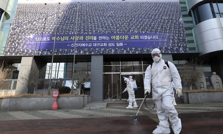 Nhân viên vệ sinh phun khử trùng tại trụ sở Tân Thiên Địa ở Daegu tuần trước. Ảnh: AFP.