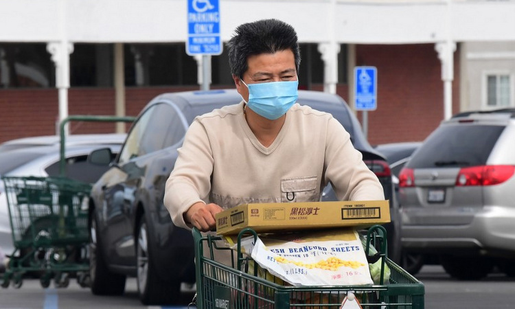 Một người đeo khẩu trang khi mua hàng tại bang California hôm 27/2. Ảnh: AFP.