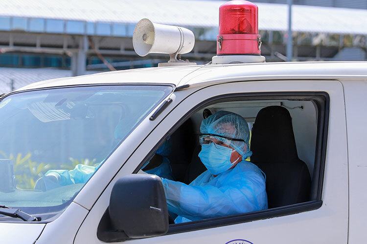 Nhân viên y tế bịt kín đồ bảo hộ khi đưa người nghi nhiễm virus corona từ sân bay về Bệnh viện Phổi. Ảnh: Nguyễn Đông.