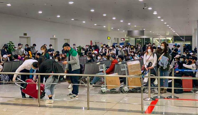 Số hành khách từ Hàn Quốc về Việt Nam tối 27/2 ngồi chờ tại tầng 2 để kiểm soát y tế. Ảnh: Giang Kim Bùi