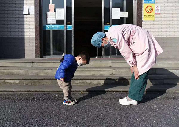 Cậu bé cúi chào cô y tá trước cổng bệnh viện, gọi cô là Mẹ y tá - Ảnh 1.