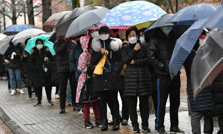Người dân thành phố Daegu, Hàn Quốc xếp hàng trong mưa chờ mua khẩu trang y tế hôm nay. Ảnh: AFP.