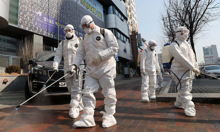 Nhân viên mặc đồ bảo hộ phun thuốc khử trùng ở thành phố Daegu hôm 20/2. Ảnh: AP.