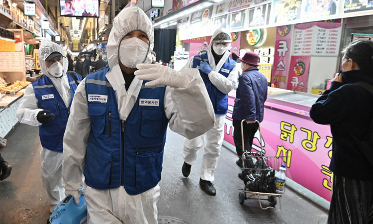 Nhân viên kiểm dịch Hàn Quốc phun thuốc khử trùng tại một khu chợ ở thủ đô Seoul hôm 24/2. Ảnh: AFP.