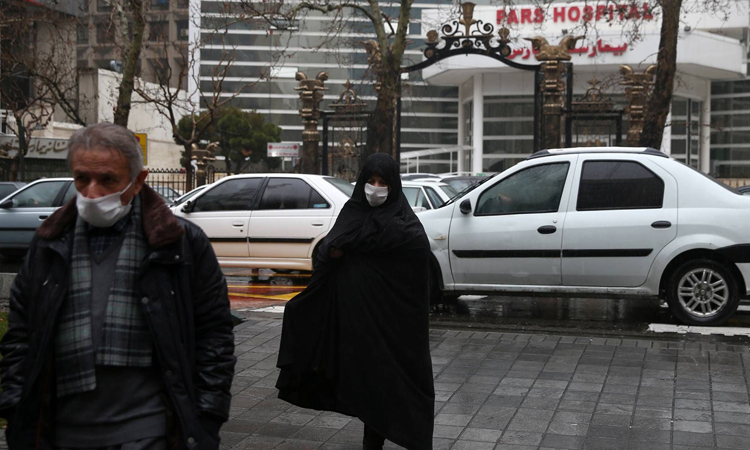 Hai người dân đeo khẩu trang bên ngoài bệnh viện ở thủ đô Tehran, Iran. Ảnh: NY Times.