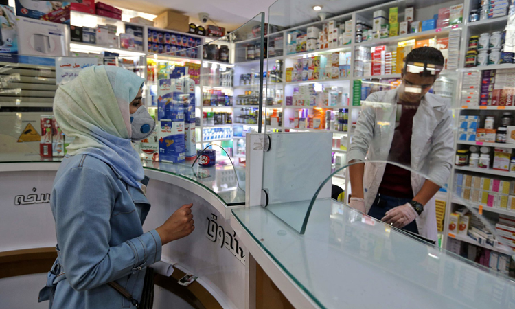 Người phụ nữ đeo khẩu trang tại hiệu thuốc ở thủ đô Tehran, Iran. Ảnh: AFP.