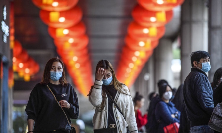 Người đi bộ đeo khẩu trang ở Macau vào ngày 22/1. Hong Kong và Macau là hai trong số những thành phố bị ảnh hưởng nặng nề nhất khi lượng khách Trung Quốc sụt giảm. Ảnh: AFP.