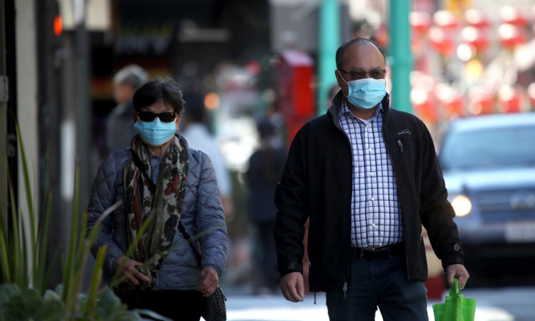 Người dân Mỹ đeo khẩu trang khi đi qua khu phố người Hoa ở San Francisco, bang California hôm 26/2. Ảnh: AFP.