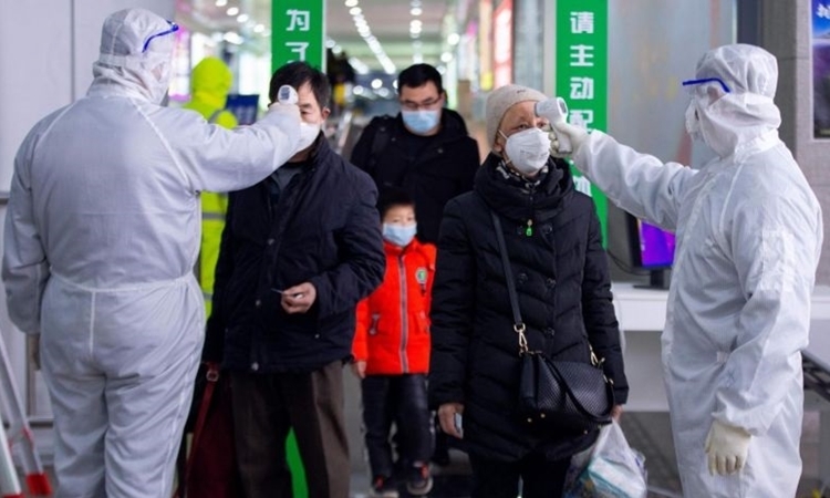 Hành khách ở một nhà ga tại Nam Kinh được kiểm tra sức khỏe hôm 18/2. Ảnh: AFP.