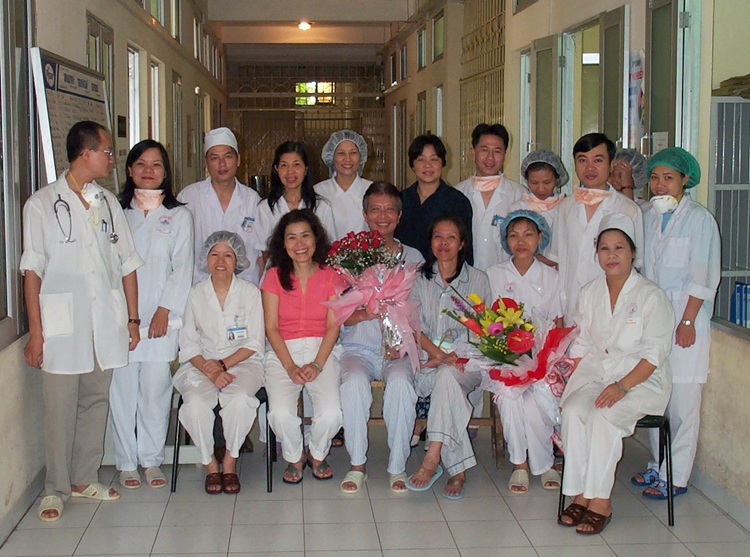 Y tá Nguyễn Thị Thục (người đầu tiên bên phải) cùng các đồng nghiệp chụp hình lưu niệm với bệnh nhân Sars, ông Hùng (ôm hoa hồng). Ảnh: Nhân vật cung cấp.