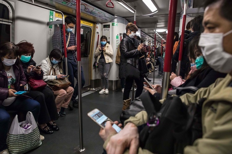 Hành khách đeo khẩu trang trên tàu điện ngầm ở Hong Kong. Ảnh: AFP.