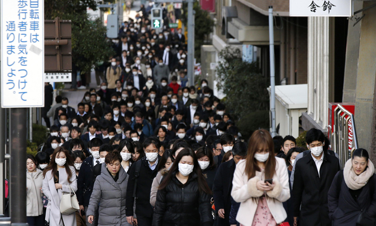 Dòng người đeo khẩu trang đi trên phố ở quận Chuo, Tokyo, Nhật Bản sáng 20/2. Ảnh: AP.