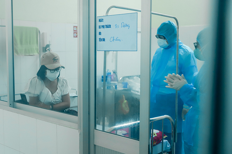 Ông Huỳnh Đức Thơ (đứng giữa) mặc đồ bảo hộ vào thăm và động viên người bệnh ở khu vực cách ly của Bệnh viện Phổi Đà Nẵng, hôm 5/2. Ảnh: Nguyễn Đông.
