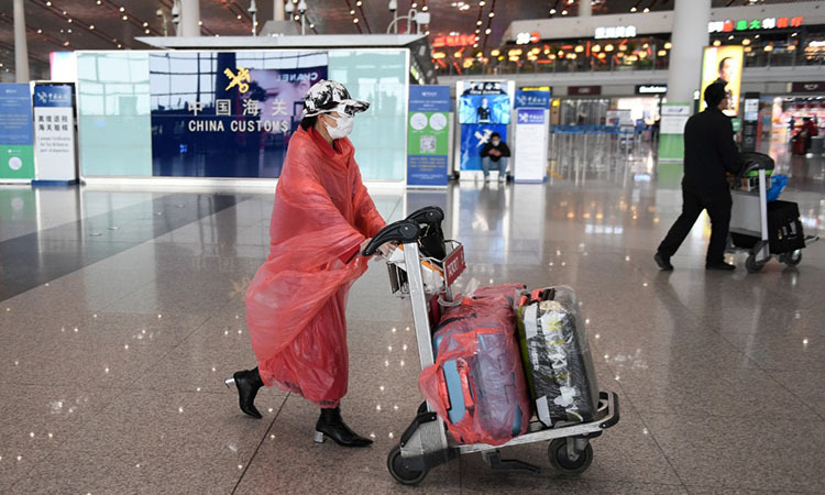 Hành khách tại sân bay quốc tế Thủ đô Bắc Kinh hôm 24/2. Ảnh: AFP.
