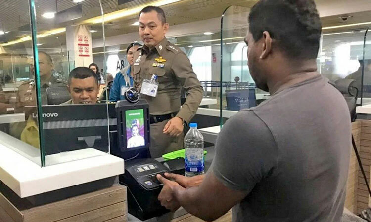 Nhân viên kiểm soát xuất nhập cảnh Thái Lan hướng dẫn hành khách lấy vân tay. Ảnh: Thaiger.