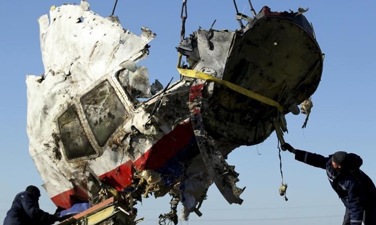 Công nhân vận chuyển mảnh vỡ của máy bay MH17 ở miền đông Ukraine tháng 7/2014. Ảnh: Reuters.