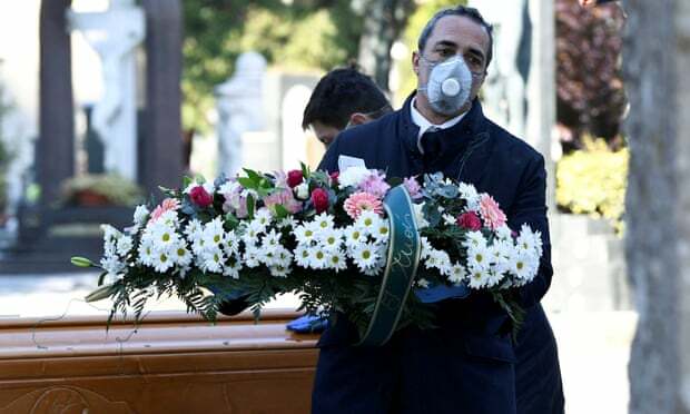 Nhân viên tang lễ vận chuyển quan tài của một bệnh nhân qua đời vì virus corona vào nghĩa trang ở Bergamo. Ảnh: Flavio Lo Scalzo/Reuters.