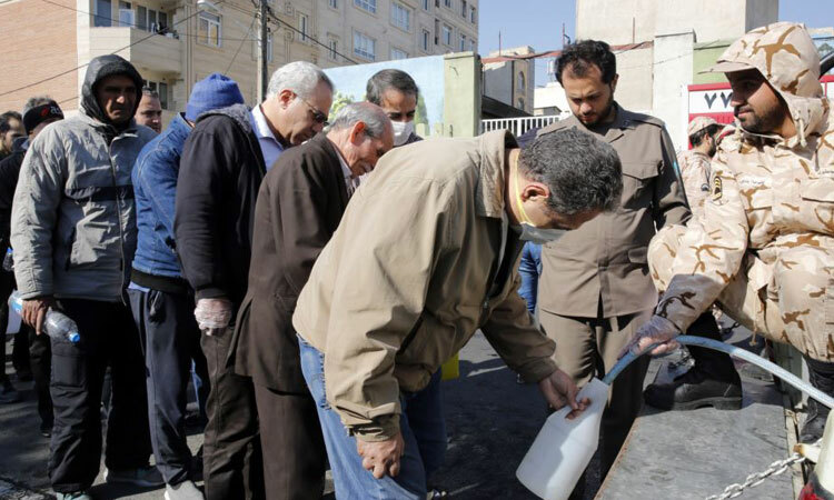 Người dân Tehran xếp hàng nhận chất khử trùng của Vệ binh Cách mạng Hồi giáo hôm 5/3. Ảnh: EFE.