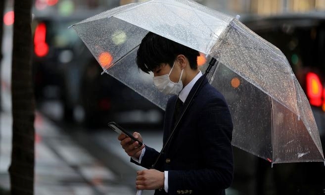 Một người đi trên đường phố tại Tokyo ngày 10/3. Ảnh: Reuters.