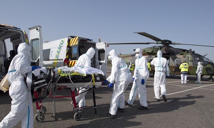 Nhân viên y tế di chuyển một bệnh nhân nhiễm nCoV ở Metz, phía đông nước Pháp, đến Essen, Đức, ngày 28/3. Ảnh: AP.