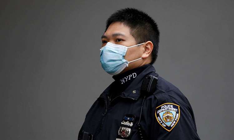 Một sĩ quan Sở cảnh sát thành phố New York (NYPD) đeo khẩu trang tại quận Manhattan, New York, Mỹ hôm 20/3. Ảnh: Reuters.