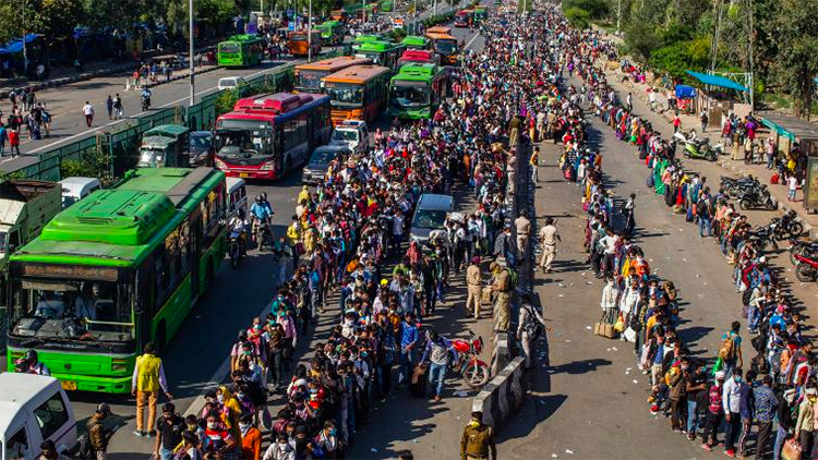 Hàng nghìn lao động nhập cư chờ lên xe buýt về quê sau lệnh phong toả ở ngoại ô New Delhi hôm 28/3. Ảnh: AFP