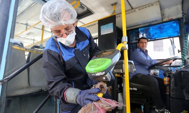 Nhân viên vệ sinh công cộng làm sạch xe bus ở Tehran ngày 10/3. Ảnh: Reuters.