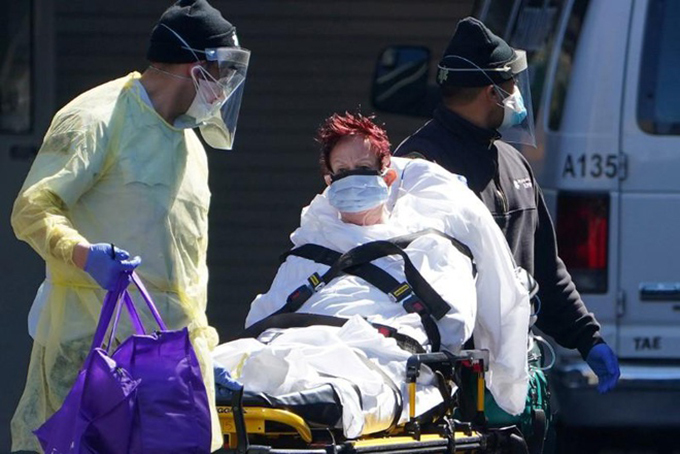 Một bệnh nhân Covid-19 được đưa đến xe cứu thương đưa đi tại quận Manhattan của thành phố New York, Mỹ hôm 26/3. Ảnh: Reuters. 