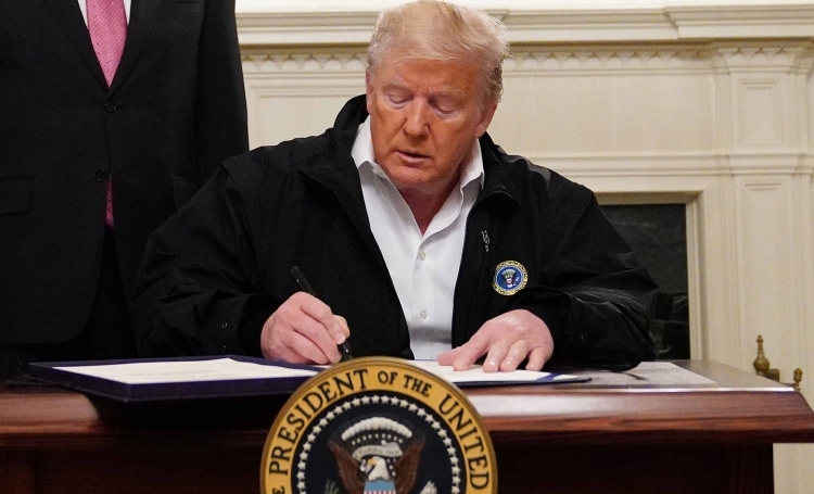 Tổng thống Mỹ Donald Trump ký dự luật 8.3 tỷ USD chống Covid-19 tại phòng tiếp tân ngoại giao ở Nhà Trắng, Washington, hôm 6/3. Ảnh: AFP.