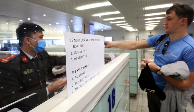 Công an cửa khẩu Nội Bài ngoài kiểm tra hộ chiếu, vé máy bay, từ ngày 7/3 kiểm tra thêm tờ khai y tế của khách. Ảnh: Bá Đô