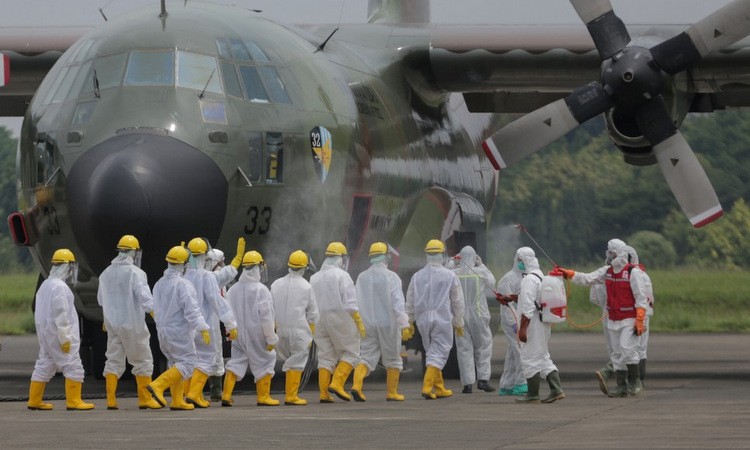 Binh sĩ Indonesia chuẩn bị chuyển thiết bị y tế tại sân bay Jakarta hôm 23/3. Ảnh: AFP.