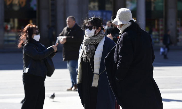 Du khách đeo khẩu trang khi đi trên đường phố Milan, Italy hôm 28/2. Ảnh: AFP.