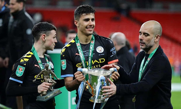 Rodri nâng cúp, bên cạnh HLV Guardiola và Phil Foden. Ảnh: Reuters.