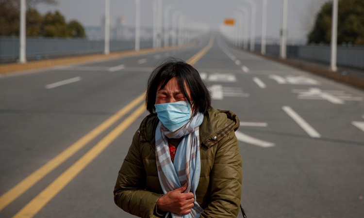 Bà Lư Dược Tiến khóc nức nở trên cầu qua sông Dương Tử, tỉnh Giang Tây hôm 1/2. Ảnh: Reuters.