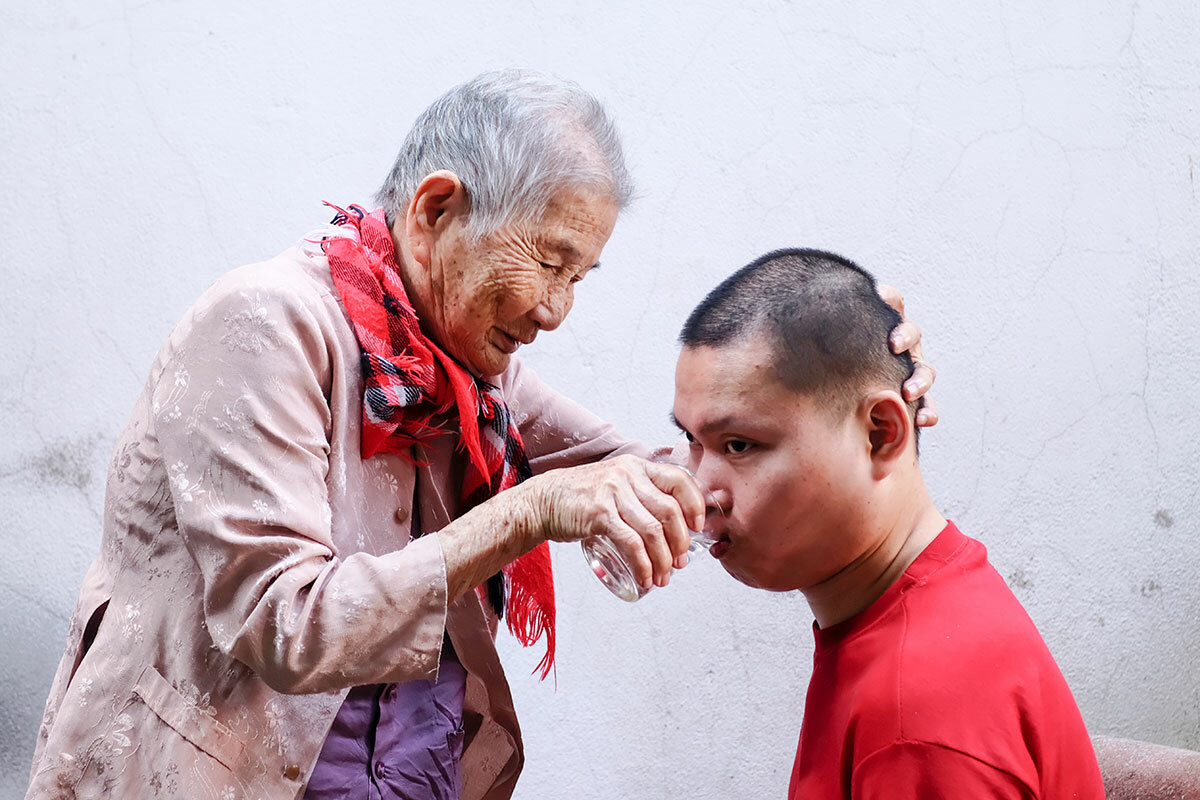 Mẹ Chi chăm sóc người cháu bị đông kinh. Ảnh: Nguyễn Đông.