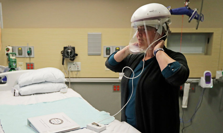 Một y tá ở thành phố Everett, bang Washington, Mỹ trình bày cách đeo mũ bảo hộ có tấm chắn mặt hôm 23/1. Ảnh: AP.