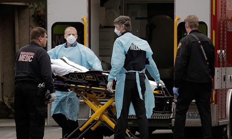 Nhân viên y tế Mỹ di dời bệnh nhân Covid-19 lên cáng cứu thương ở bang Washington đầu tháng này. Ảnh: Reuters.