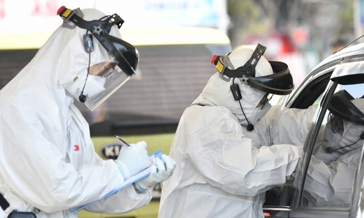 Nhân viên y tế Hàn Quốc lấy mẫu xét nghiệm từ tài xế nghi nhiễm nCoV ở phía bắc Seoul hôm 29/2. Ảnh: AFP.