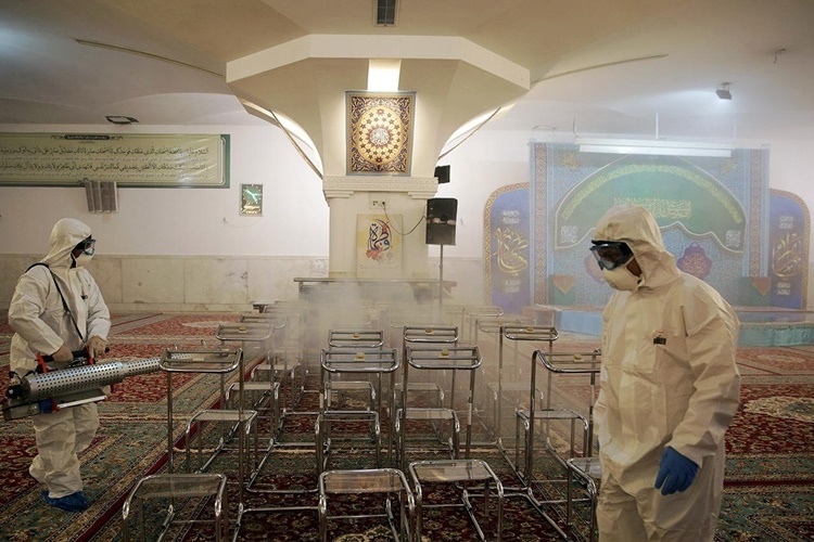 Nhân viên y tế tẩy trùng một nhà thờ Hồi giáo ở Mashhad, Iran, ngày 27/2. Ảnh: Reuters.