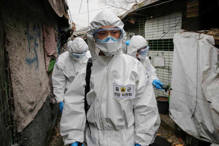 Binh sĩ Hàn Quốc mặc đồ bảo hộ thực hiện công tác tẩy trùng tại làng Guryong ở Seoul, Hàn Quốc, ngày 3/3. Ảnh: Reuters.