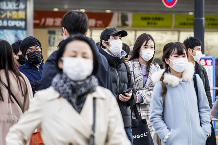 Người dân Tokyo đeo khẩu trang để phòng Covid-19 khi đi làm vào giờ cao điểm ngày 25/2. Ảnh: Bloomberg