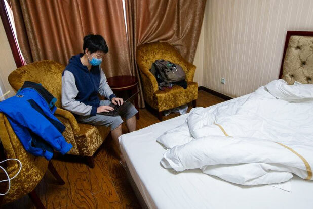 Du học sinh Trung Quốc đeo khẩu trang trong phòng khách sạn được dùng làm khu vực cách ly tại thành phố Thái Nguyên, tỉnh Sơn Tây ngày 17/3. Ảnh: Reuters.