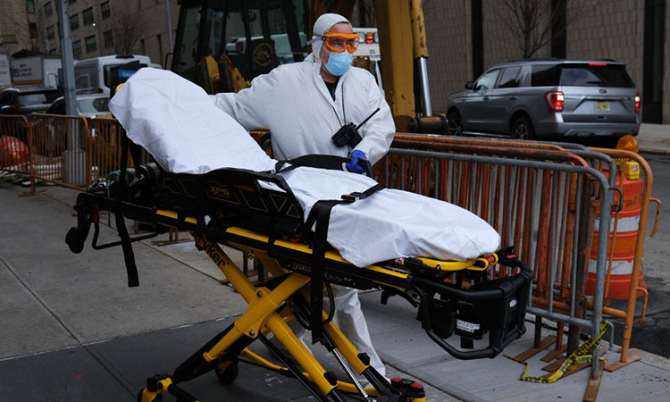 Một tài xế xe cứu thương cất xe đẩy bên ngoài một bệnh viện ở thành phố New York, Mỹ hôm 31/3. Ảnh: AFP.